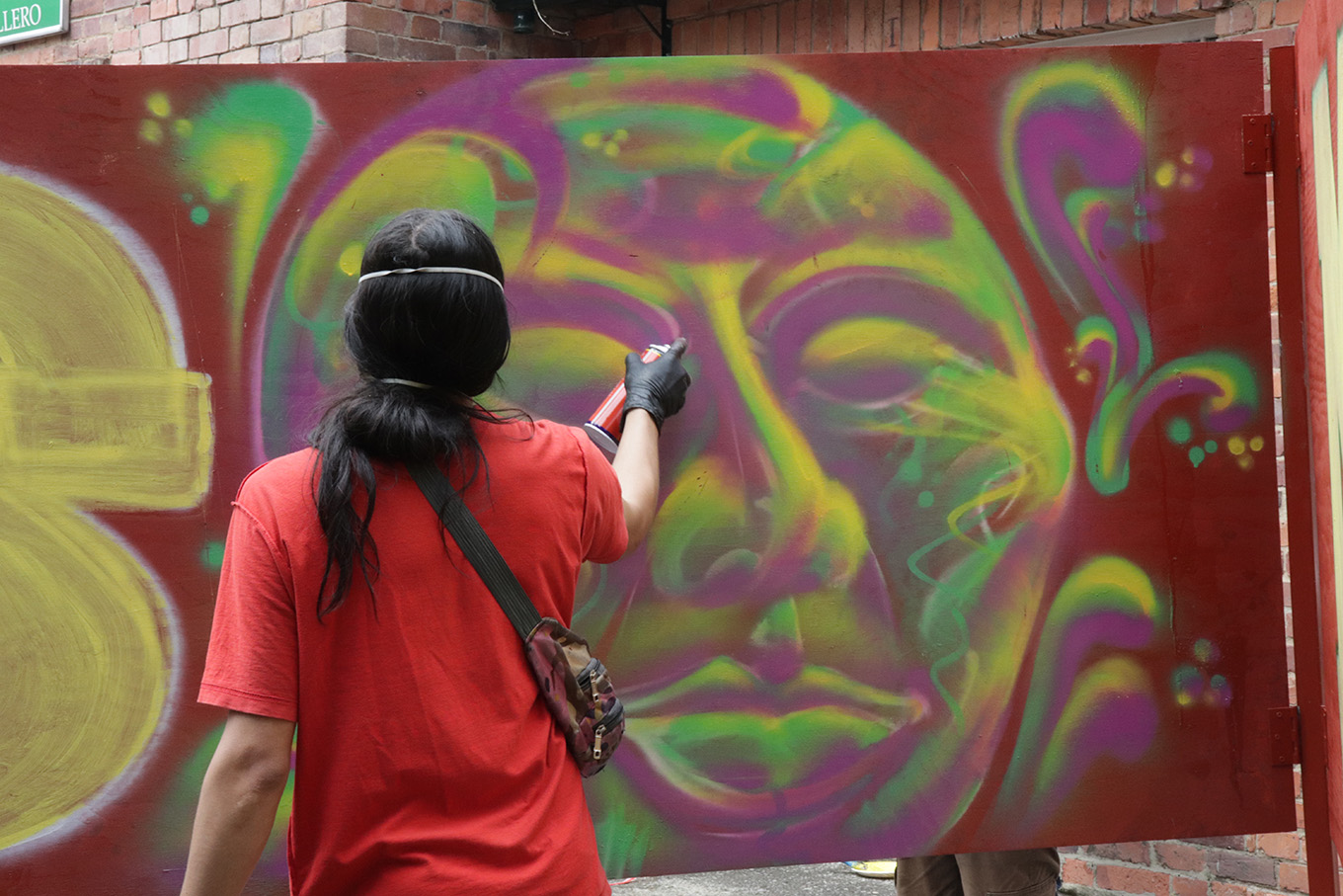en la imagen, el artista plástico Fike, quien a través del graffiti pintó el rostro representativo del evento «Respiramos memorias»